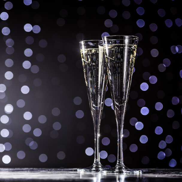 Two glasses of champagne on dark bokeh background - Foto, imagen