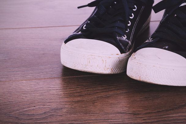 Zapatos de lona viejos en un suelo de madera Vintage Retro Filter
. - Foto, imagen