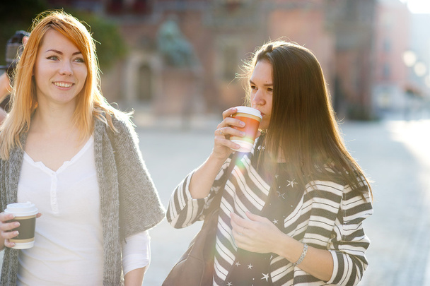 Morning. Nice young women standing on the square of the beautiful European city. - 写真・画像