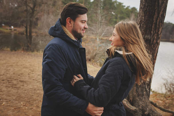 amando jovem casal feliz juntos ao ar livre em acolhedor passeio quente na floresta de outono
 - Foto, Imagem