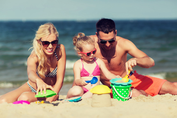boldog család olyan játékokkal játszani, homokos tengerparton - Fotó, kép