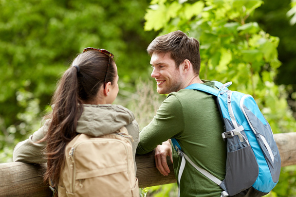 smiling couple with backpacks in nature - Fotó, kép
