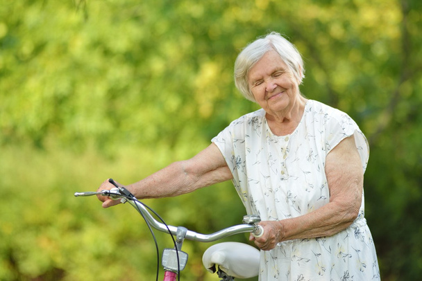 Senior woman with bike - Foto, imagen
