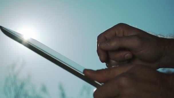 Close-up van mannenhand met behulp van de Ipad op een zonnige dag - Video
