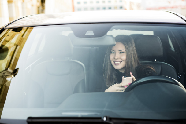 brunette woman sitting on driver seat  - Zdjęcie, obraz