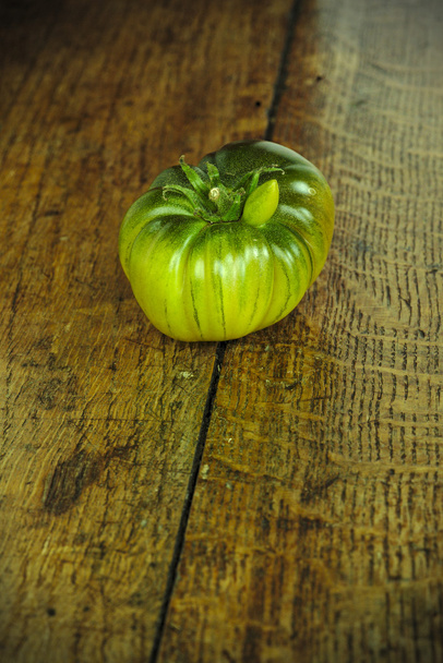 Pomodoro di manzo verde su un tavolo di legno scuro 1
 - Foto, immagini