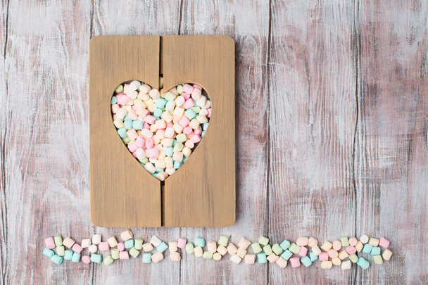Pequenos marshmallows no quadro de coração de madeira
. - Foto, Imagem
