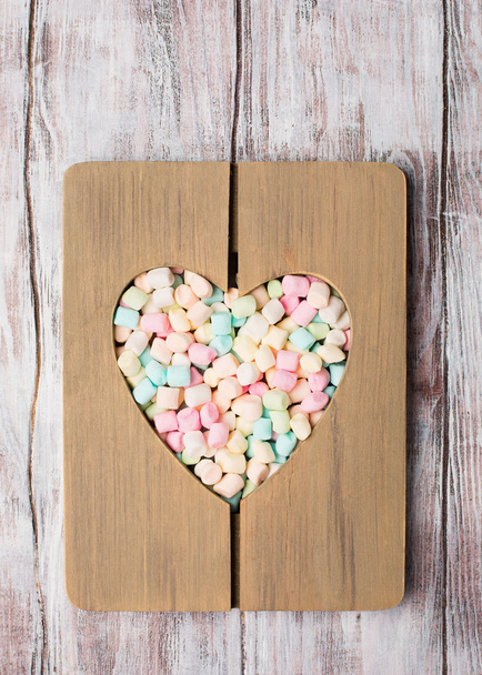 Pienet vaahtokarkit puinen sydän runko
 - Valokuva, kuva