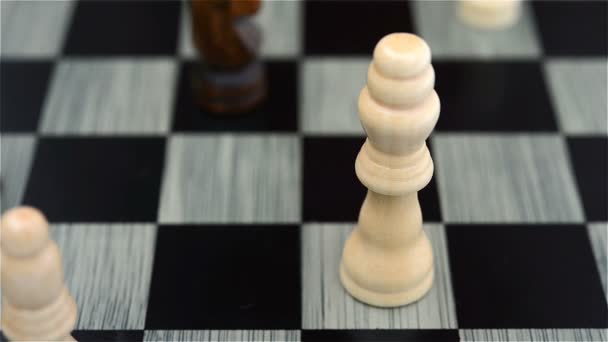 black chess player knocks down the white king with his Knight - Footage, Video
