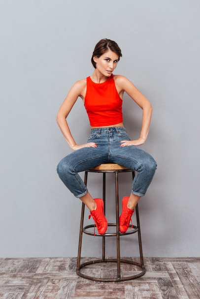 Full length portrait of a serious girl sitting on chair - Photo, image
