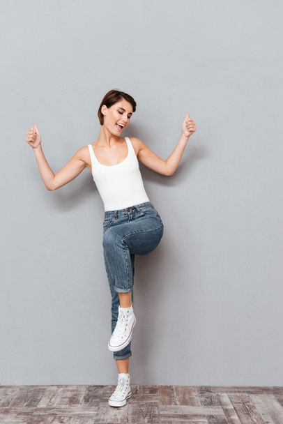 Full length portrait of smiling woman with raised hands up - Photo, image