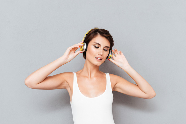 Beautiful brunette young woman listening to music with headphones - Fotografie, Obrázek