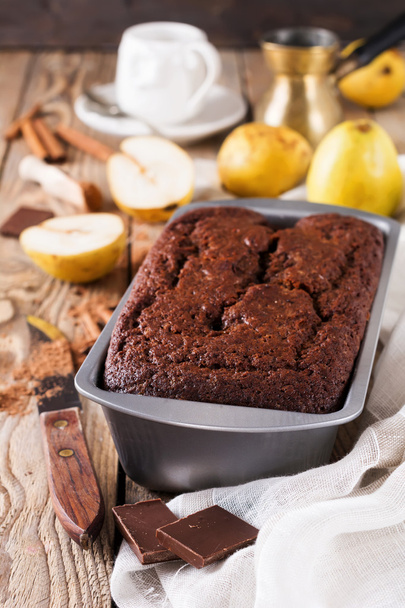 Chocolate cake with pears and cinnamon on old wooden background. Selective focus. - Foto, immagini