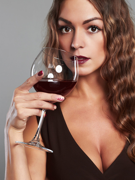 gorgeous μελαχρινή κοπέλα με ποτήρι κόκκινο κρασί. Όμορφη ξανθιά γυναίκα πίνοντας κόκκινο κρασί - Φωτογραφία, εικόνα