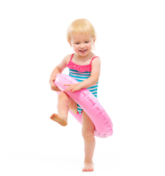 Baby girl in swimsuit playing with inflatable ring - Foto, immagini