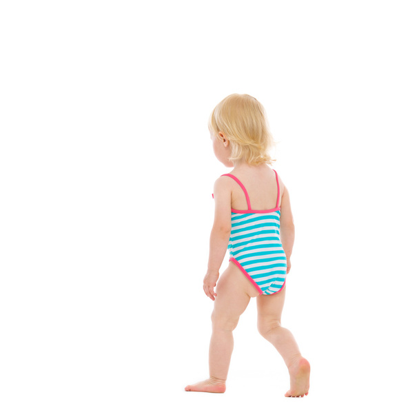 Baby in swimsuit walking away. Rear view - Foto, imagen