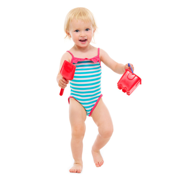 Baby girl in swimsuit holding bucket and shovel - Photo, Image