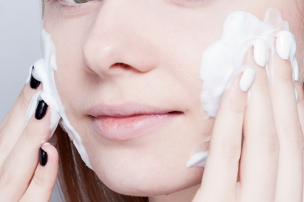 Close-up woman clears skin foam on gray background - Φωτογραφία, εικόνα