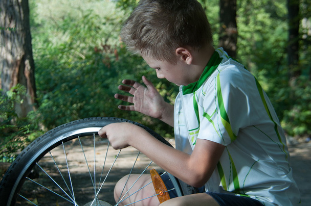 boy repairing a bicycle wheel - Photo, Image