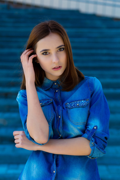 Portrait of a beautiful girl in blue on stairs - Fotografie, Obrázek