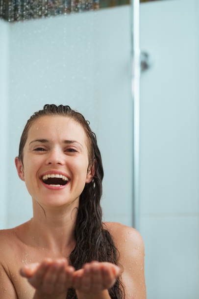Happy woman catching water drops in shower under water jet - Zdjęcie, obraz