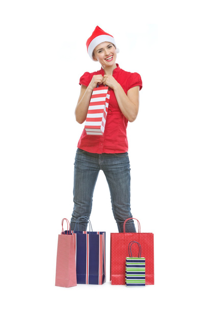 Gelukkige vrouw in kerstmuts met shopping tassen - Foto, afbeelding