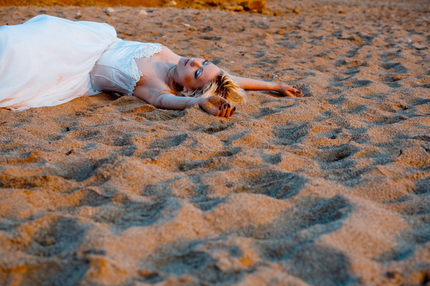 Bride lying on sand - Fotó, kép