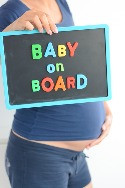 zwangere vrouw bedrijf blackboard - Foto, afbeelding