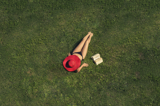 Woman lying on the grass with book - Foto, immagini
