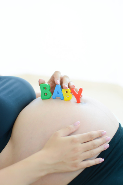 Kobieta w ciąży z kolorowych liter na brzuch  - Zdjęcie, obraz