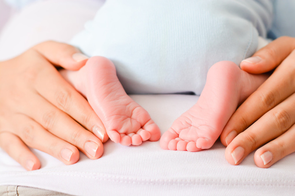 female hands and cute feet of newborn  - Photo, Image
