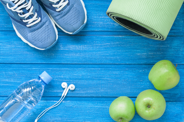 Flat lay sport shoes, bottle of water, mat and earphones - Photo, Image