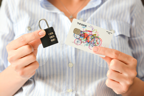 南京錠とクレジット カードを保持している女性の手 - 写真・画像