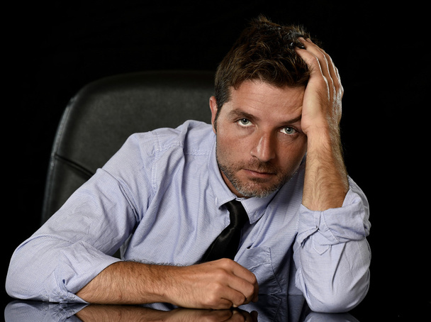 joven atractivo hombre de negocios en preocupado cansado y estresado expresión de la cara sentado deprimido en silla de oficina
 - Foto, imagen
