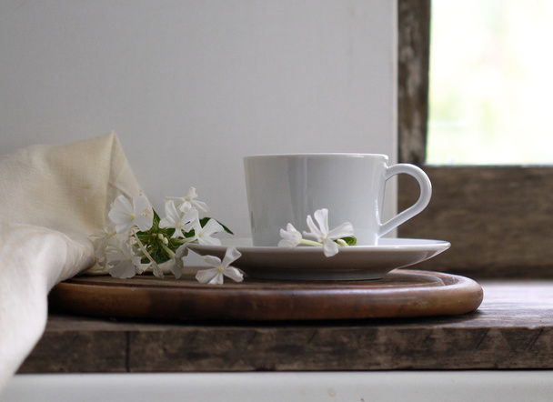 rustic still life. cup of tea on the window sill and white phlox flowers. vintage wooden background. close-up - Fotografie, Obrázek