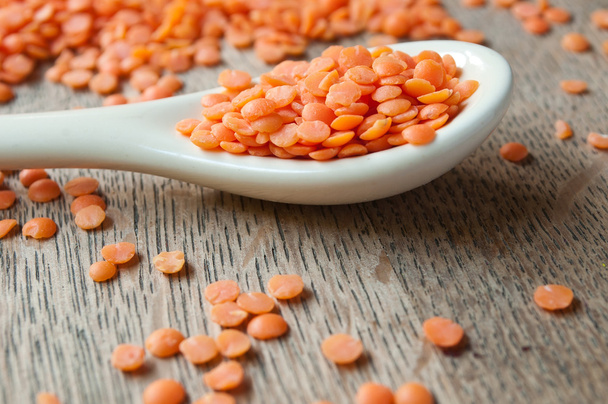 coral  lentils in a spoon on wooden background - Zdjęcie, obraz