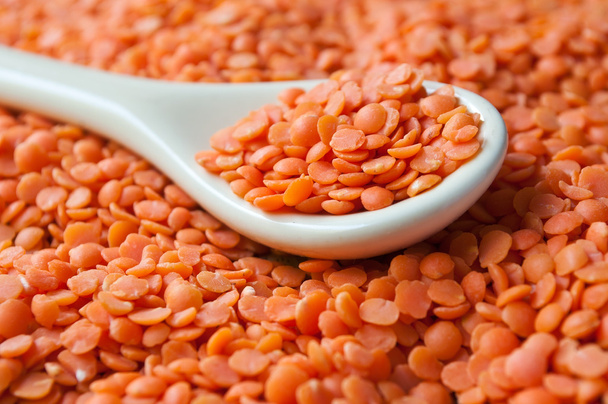 coral  lentils in a spoon on wooden background - Foto, Imagen