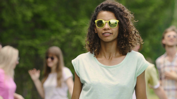 Mooie vrouw in zonnebril dansen met vrienden op zomerkamp, jeugdigheid - Video