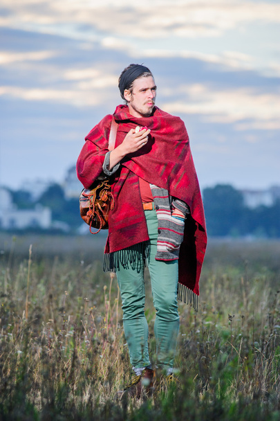 Joven hippie hombre en poncho en campo verde
 - Foto, Imagen