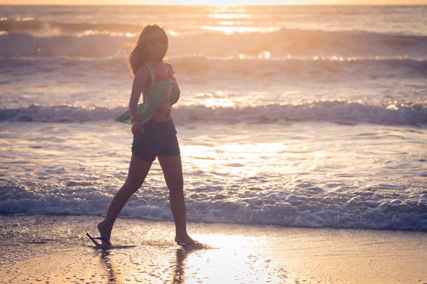 woman walking on the beach, sunshine in the morning summer sea - Foto, afbeelding