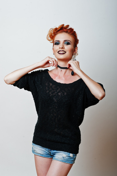 Studio portrait of red haired girl on black blouse and jeans sho - Фото, зображення