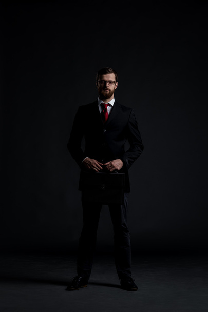 Young businessman on dark background - 写真・画像