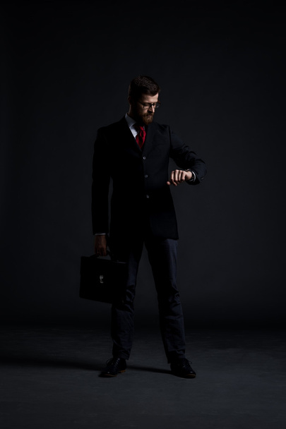 Businessman with case checking time - Foto, Imagen
