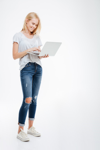 Full length portrait of a happy woman using laptop computer - Foto, immagini