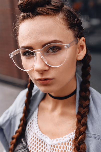 Dziewczyna w okularach z warkoczykami na zewnątrz - Zdjęcie, obraz