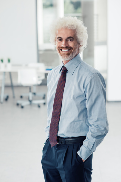 Selbstbewusster Geschäftsmann posiert im Büro - Foto, Bild