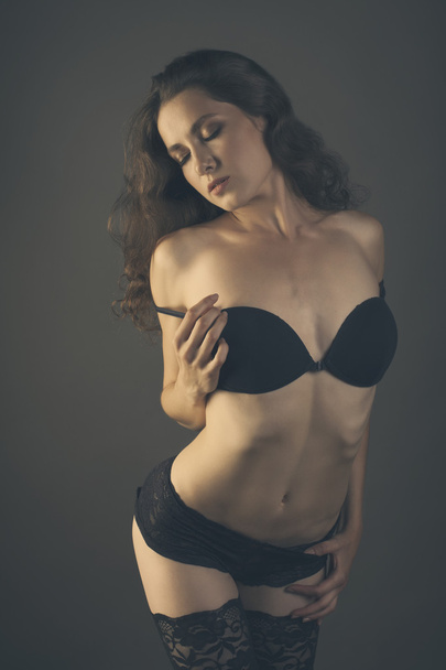 Sexy cuerpo de mujer joven en lencería negra aislado en backgro oscuro
 - Foto, imagen