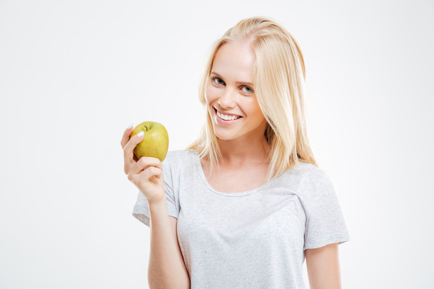 Portrait of a happy young girl holding green apple - Fotó, kép