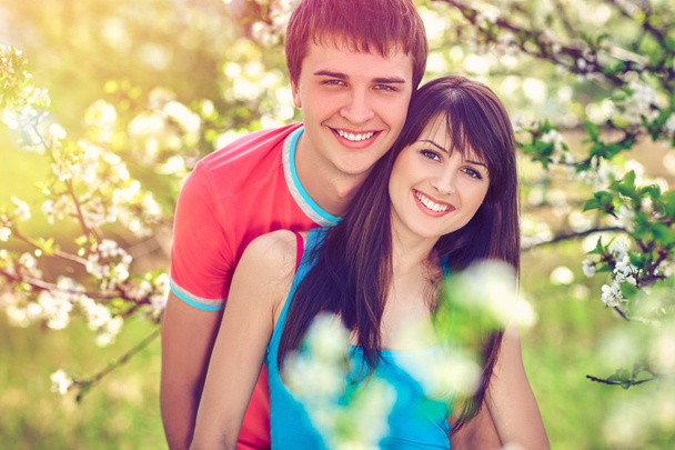 Young couple enjoying in blooming garden - Zdjęcie, obraz