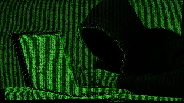Anonymous hacker in black hood with a laptop - Footage, Video